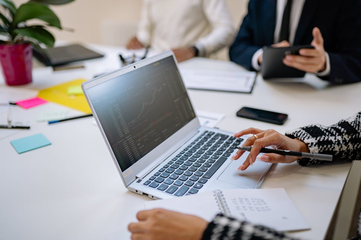 Professionals reviewing data on a laptop during a business meeting